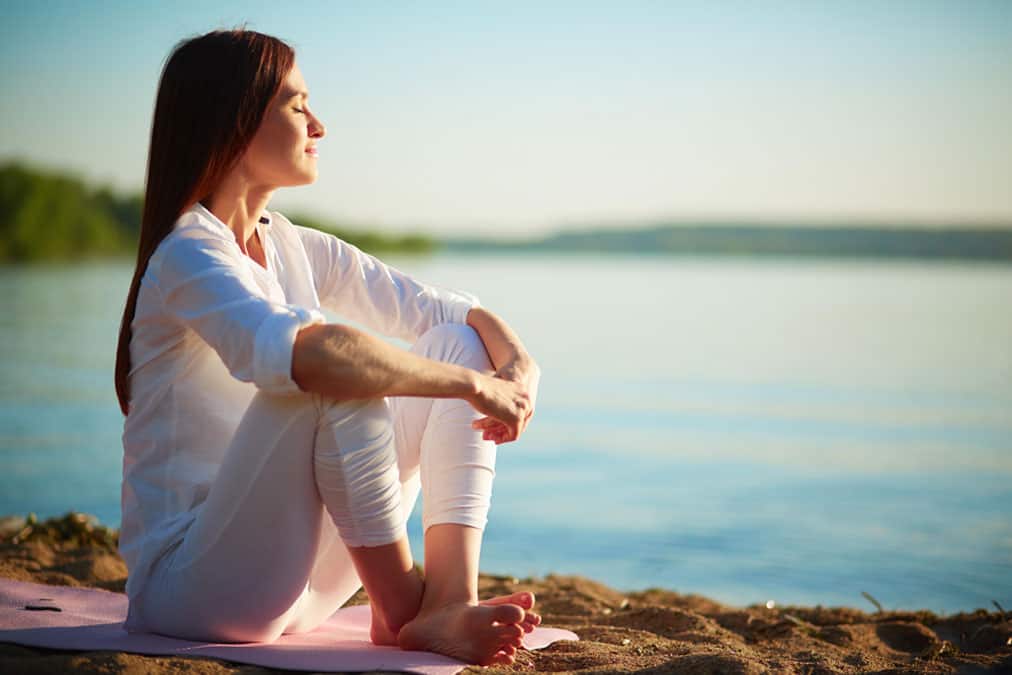 woman-sitting-peacefully-on-beach